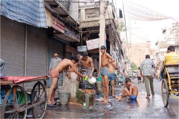 Мытье на улице в центре Дели. Индия
