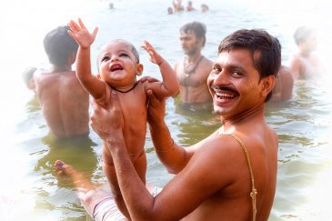 Брахман с ребёнком в водах Ганги. Варанаси. Индия