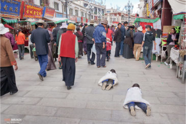 Маленькие паломники совершают простирания во время коры (обхода) вокруг храма Джоканг в Лхасе