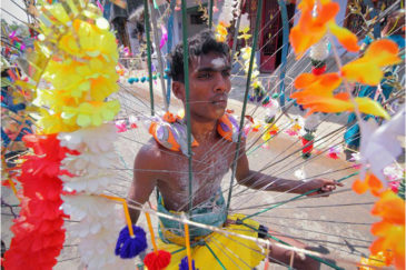 Мужчины несут статуи божеств на спицах, воткнутых в тело. Фестиваль в штате Тамилнаду