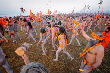 Толпа из сотен аскетов идет к священной реке Ганг на фестивале Кумбха-Мела