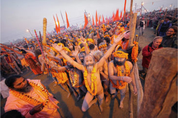 Толпа аскетов готовится искупаться в Ганге на большое Королевское омовение на фестивале Кумбха-Мела